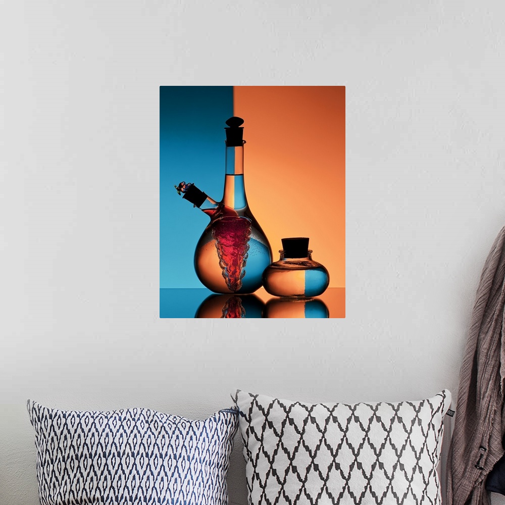 A bohemian room featuring Two glass jars of oil and vinegar reflecting backwards images of the orange and blue walls in the...