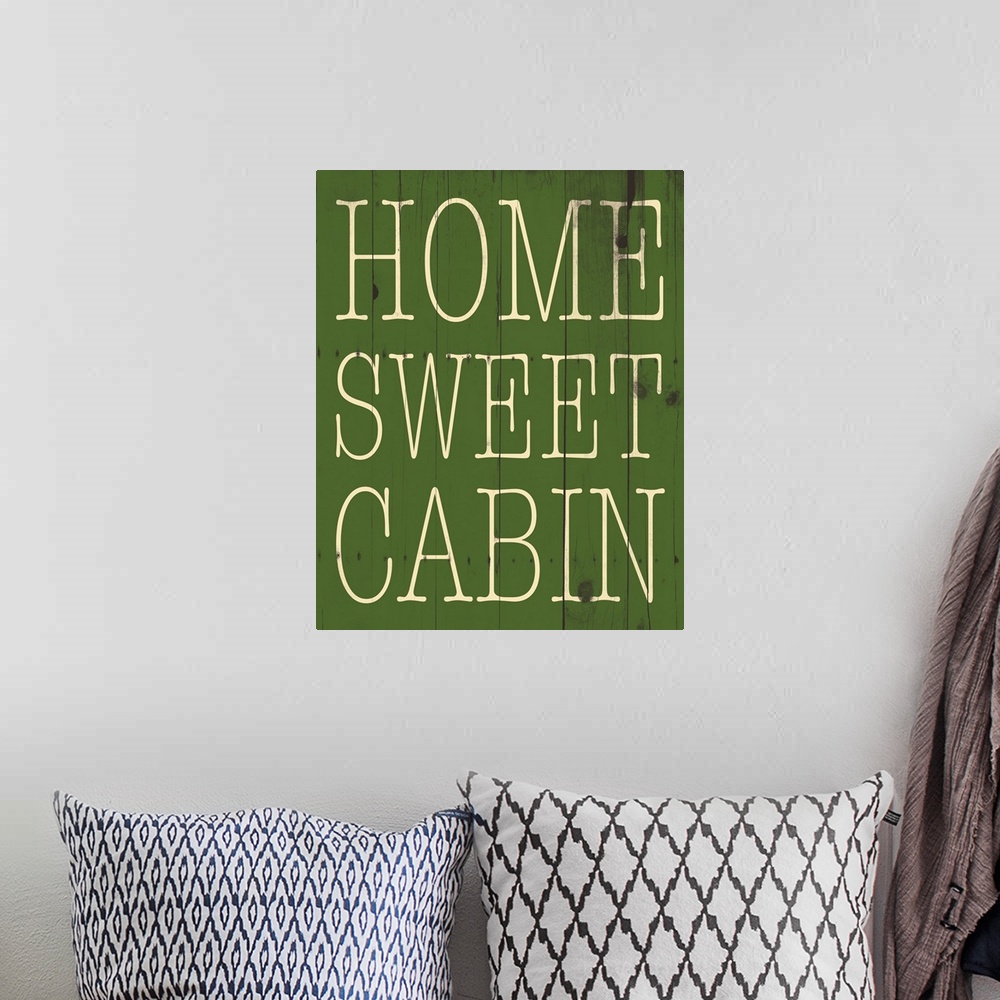 A bohemian room featuring Typographical artwork with "Home sweet cabin" in a thin rustic text.