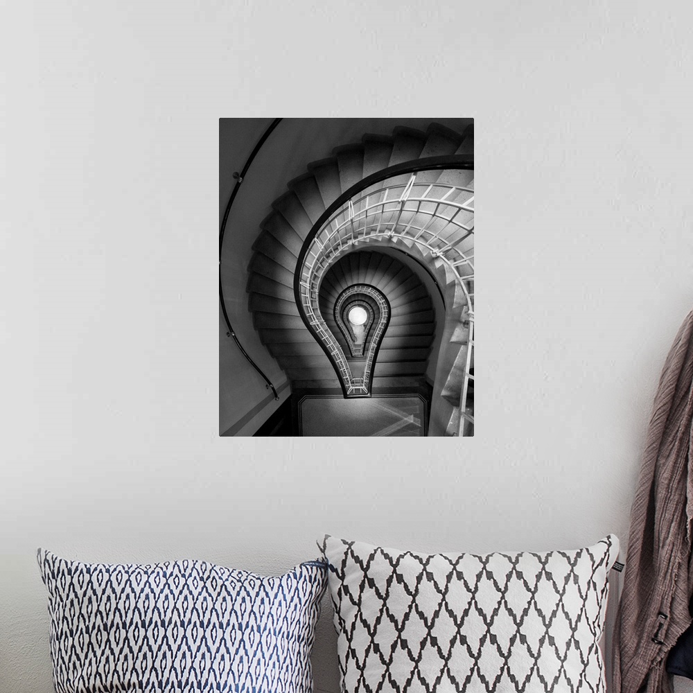 A bohemian room featuring black and white photograph, stairs, spiral staircase, lightbulb