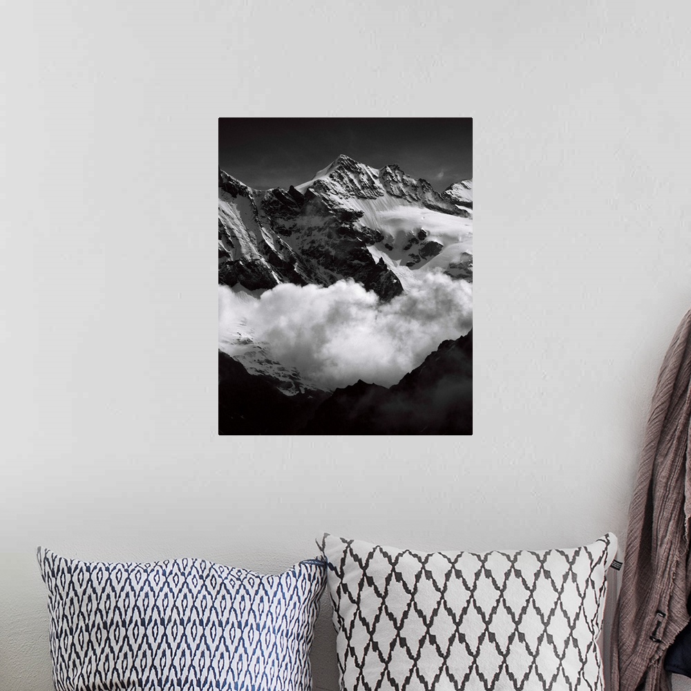 A bohemian room featuring Black and white photograph of mountain peaks surrounded by rolling clouds.