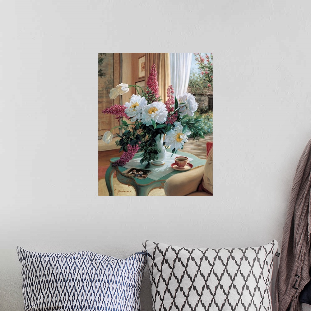 A bohemian room featuring Bouquet of Peonies, French Tulips and delphiniums in a vase on a table with coffee cup by a window.