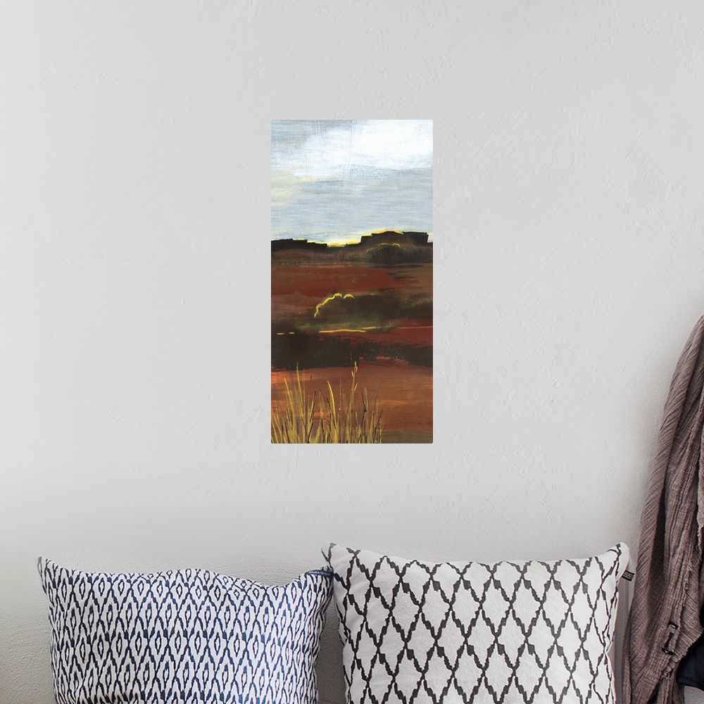 A bohemian room featuring A long vertical painting of an abstract landscape of a prairie field in textured earth tones.