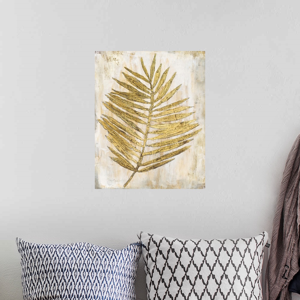 A bohemian room featuring Gold and cream decor with a palm branch that has thin leaves,