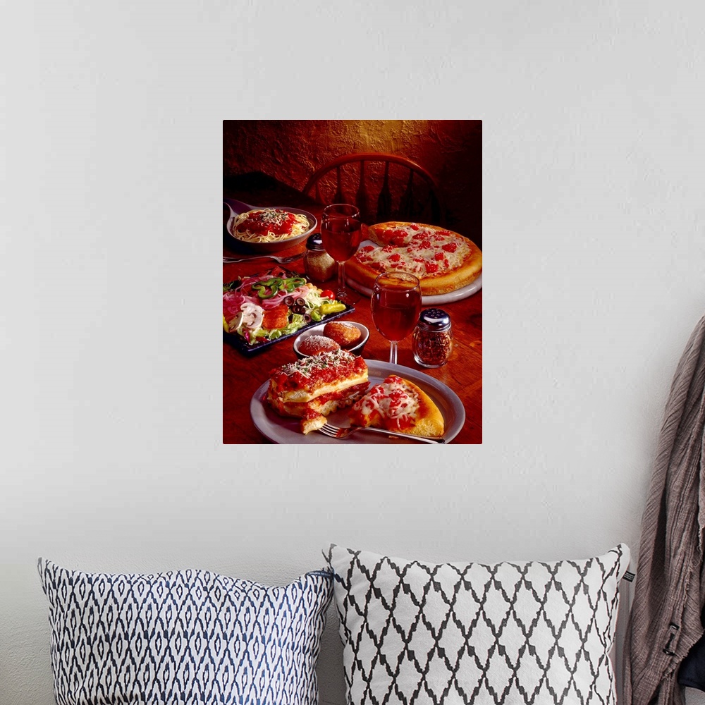 A bohemian room featuring Photograph taken of a table covered with plates of Italian food that includes pasta, pizza and an...