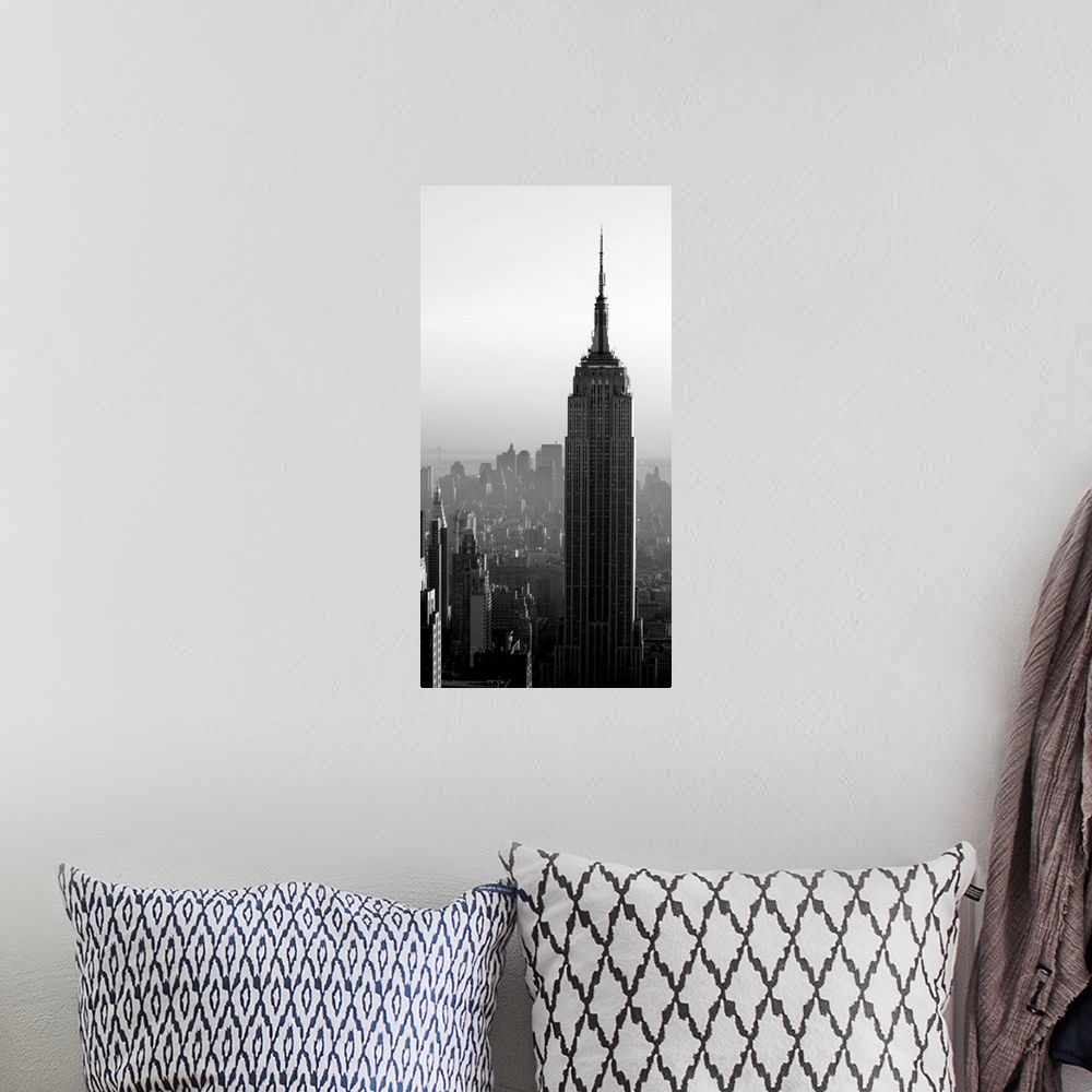A bohemian room featuring A long vertical black and white image of the Empire States Building in New York City.