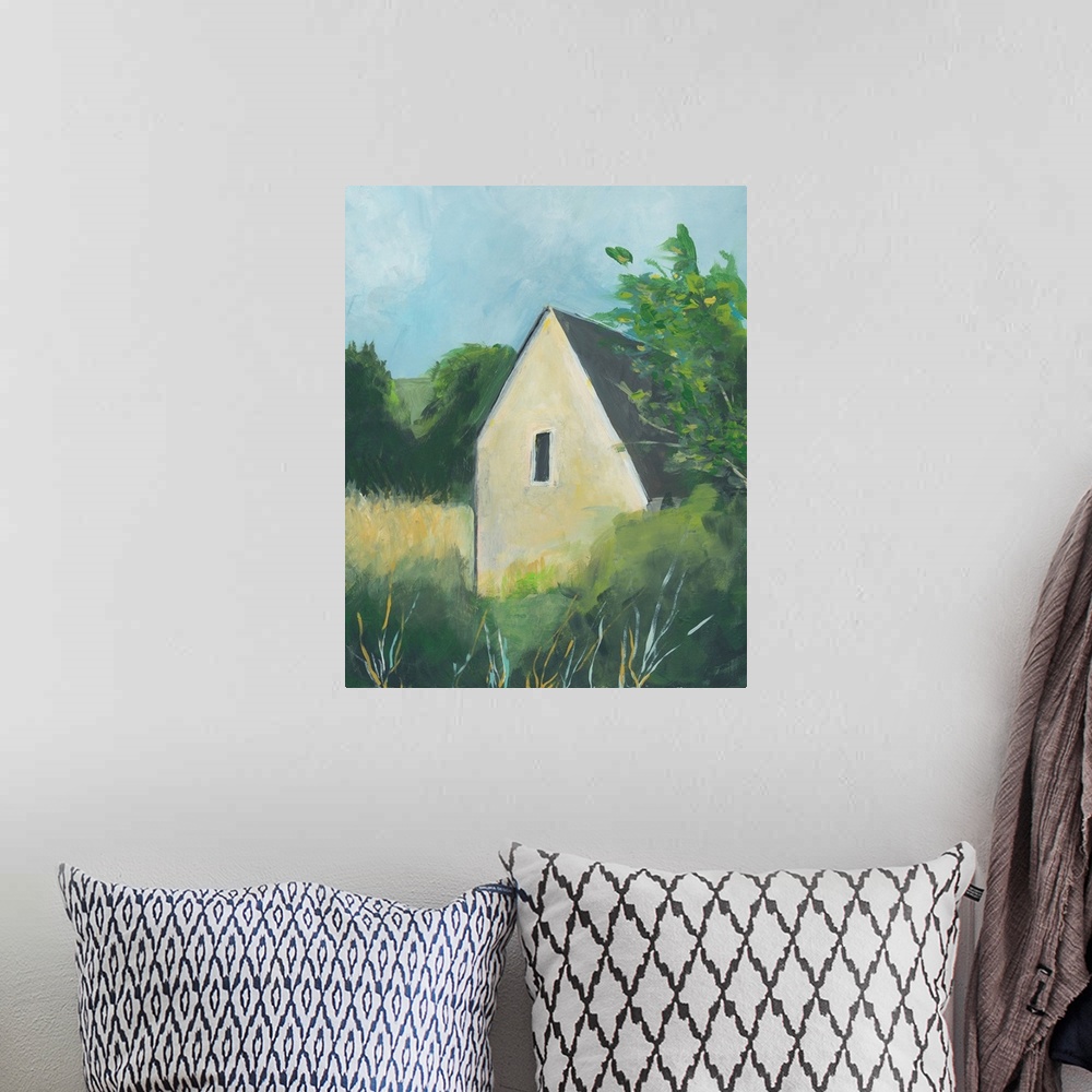A bohemian room featuring Vertical painting of a yellow house surround by trees in the country.