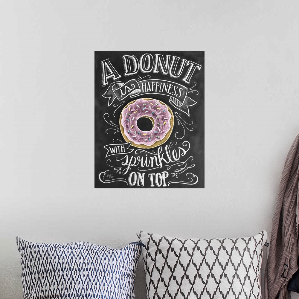 A bohemian room featuring "A donut is happiness with sprinkles on top" handwritten in white chalk with a drawing of a donut.