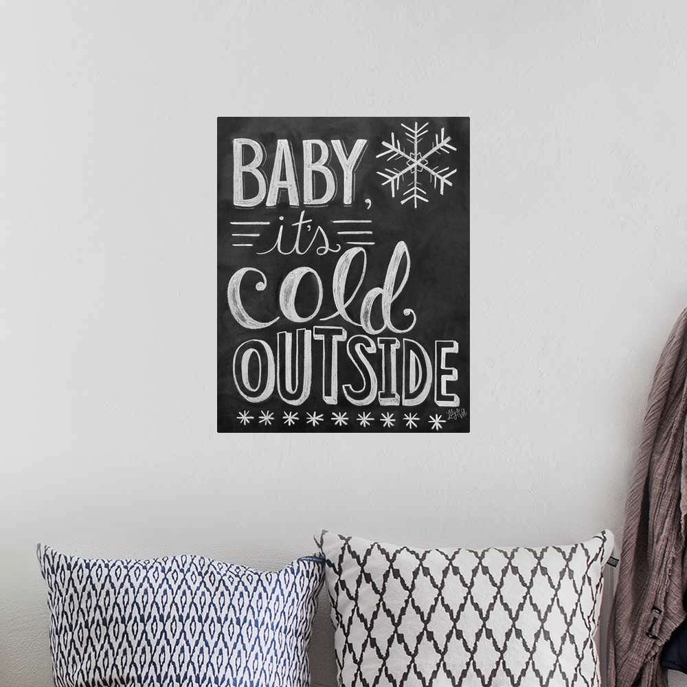 A bohemian room featuring "Baby, it's cold outside" handwritten in white chalk on a black background.