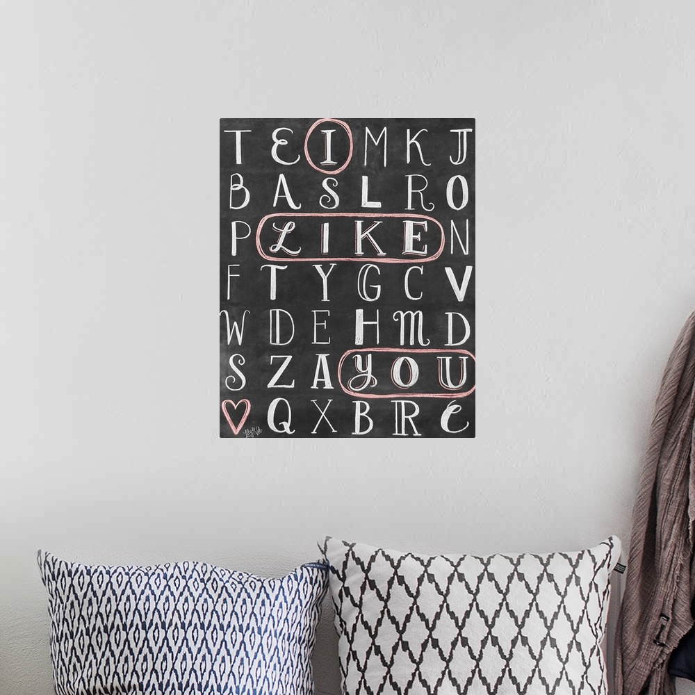 A bohemian room featuring The words "I Like You" circled in a word-search puzzle, hand written in chalk o na black background.