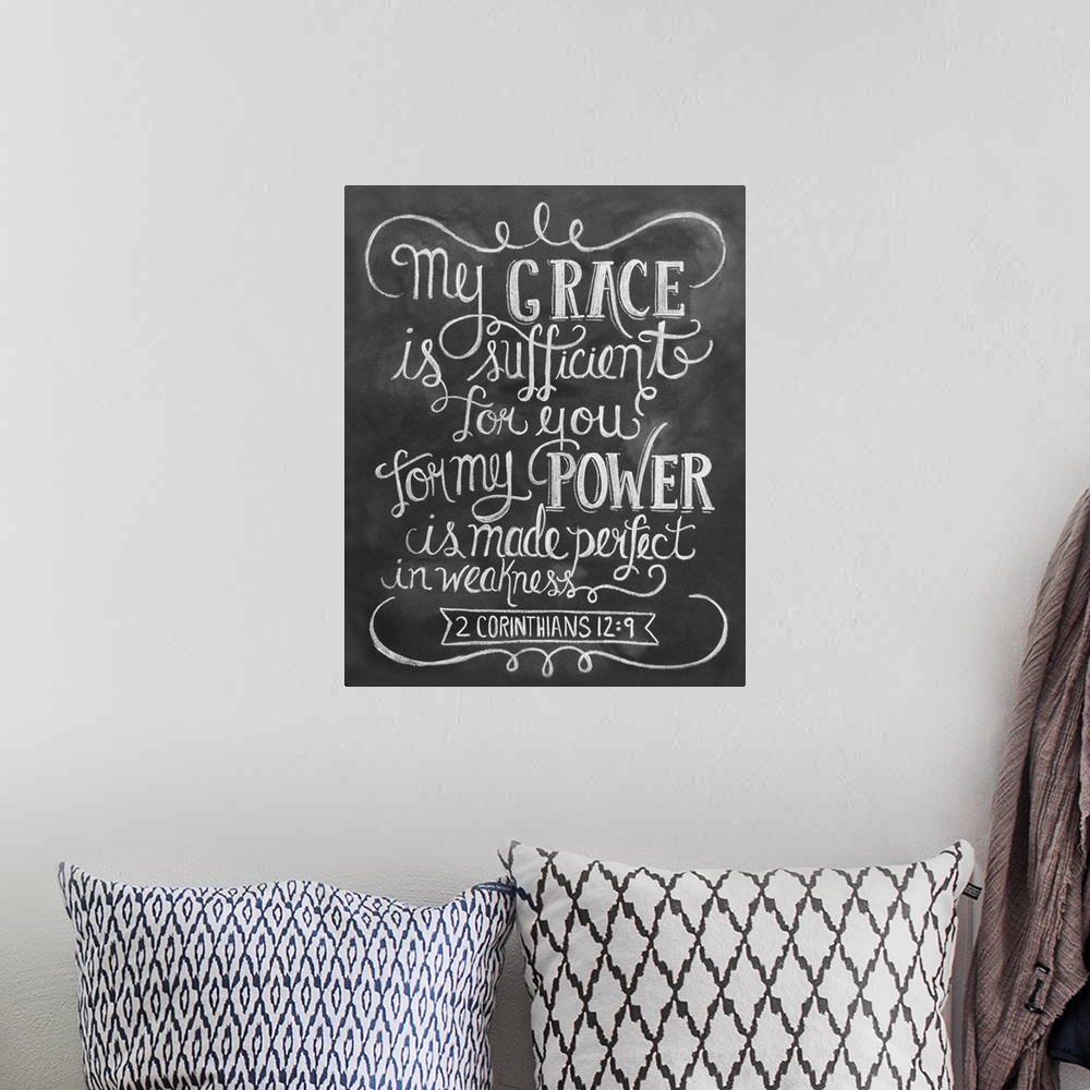 A bohemian room featuring The Bible passage 2 Corinthians 12:9 handwritten in white chalk on a black background.