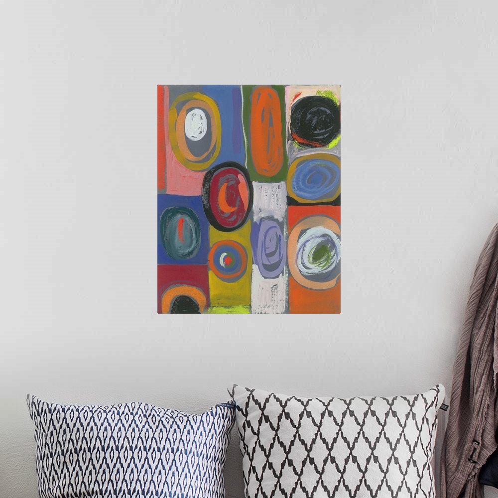A bohemian room featuring Painting of circular shapes in various hues and sizes over blocks of color.
