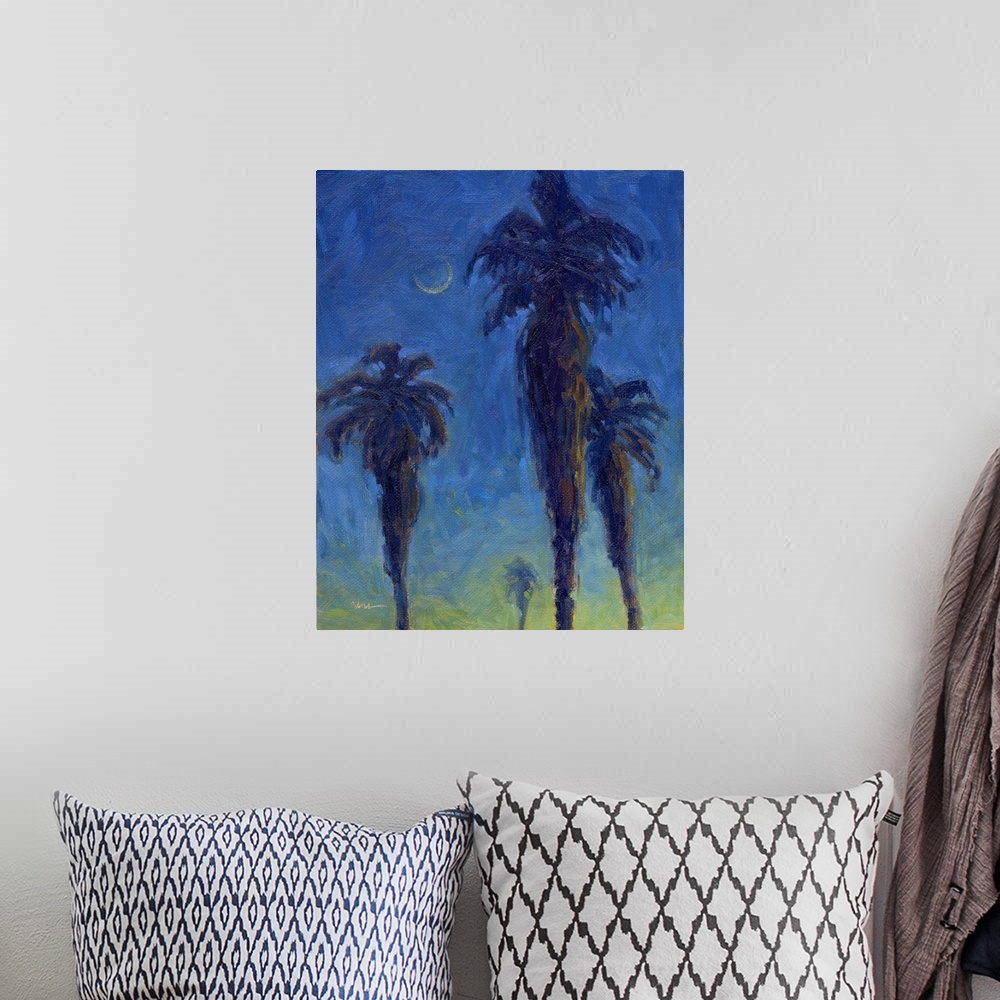 A bohemian room featuring A vertical painting of palm trees in the moonlight.
