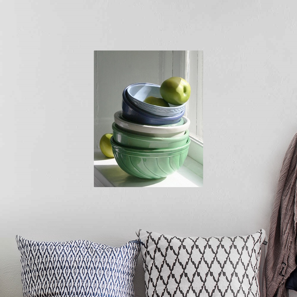 A bohemian room featuring A stack of ceramic bowls with green apples on a windowsill.