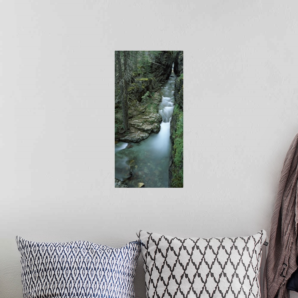 A bohemian room featuring Panoramic vertical image that looks downward on a waterfall whose water flows from a cave.