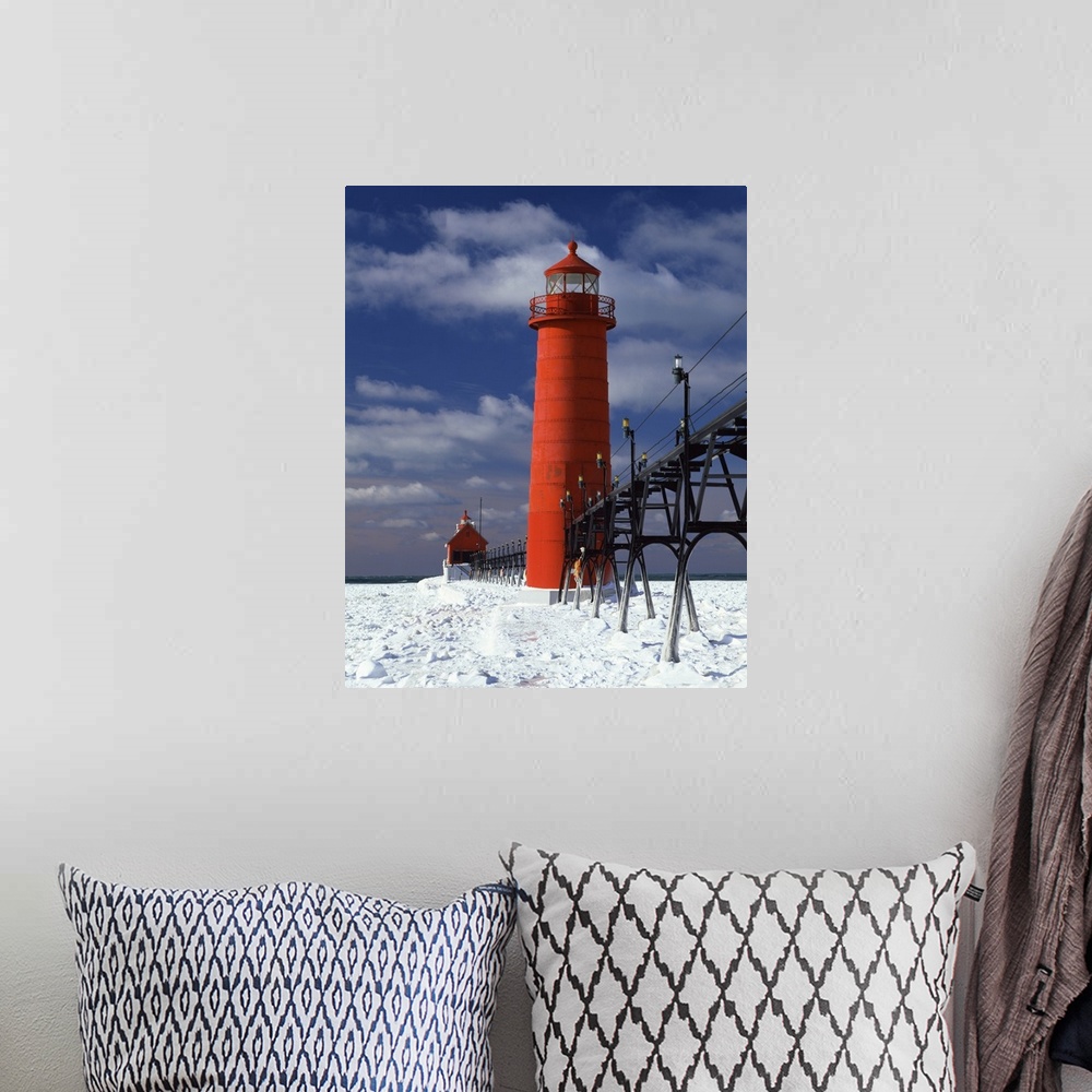 A bohemian room featuring A lighthouse in Michigan is photographed closely as snow covers the ground surrounding it.
