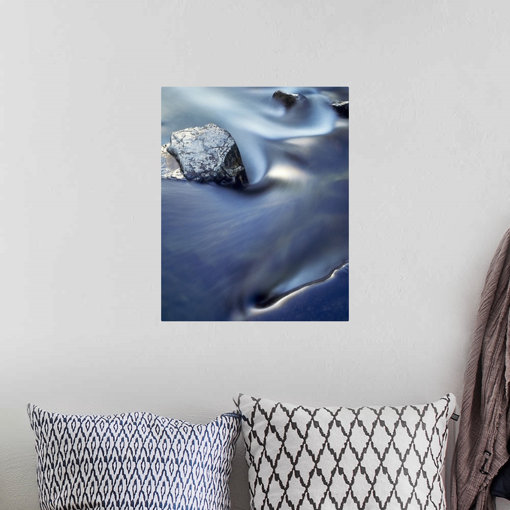 A bohemian room featuring Vertical, close up photograph on a large wall hanging  of blurred water in rapid movement as it s...
