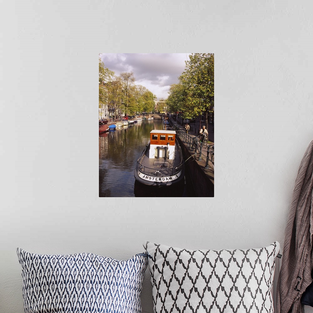 A bohemian room featuring Tourboat docked in a channel, Amsterdam, Netherlands