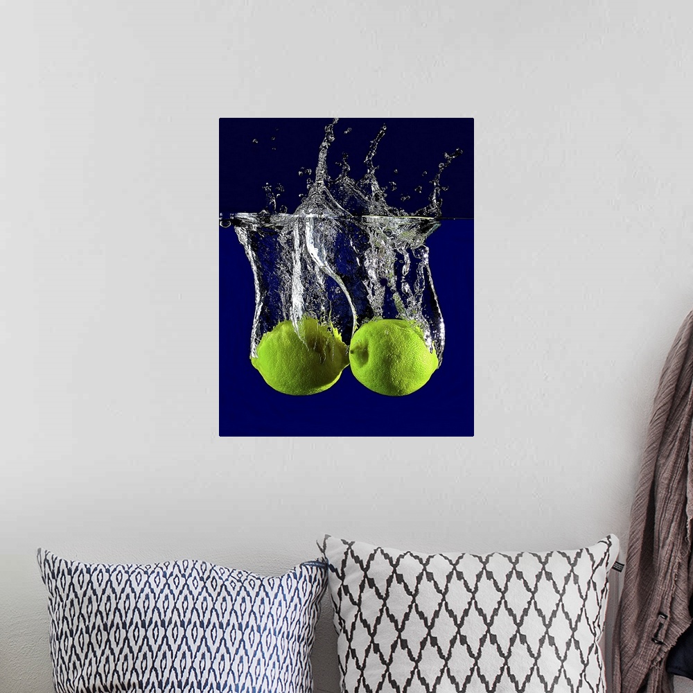 A bohemian room featuring Two green limes dropped into clear water.