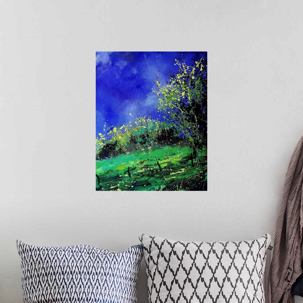 A bohemian room featuring A vertical painting of a fenced in field with a brilliant blue sky.