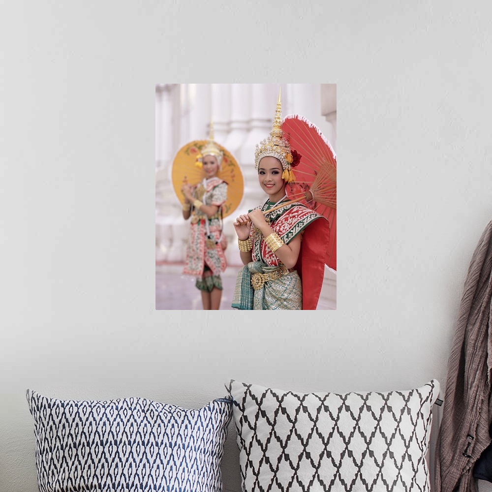 A bohemian room featuring Portrait of two dancers in traditional Thai classical dance costume, smiling and looking at the c...