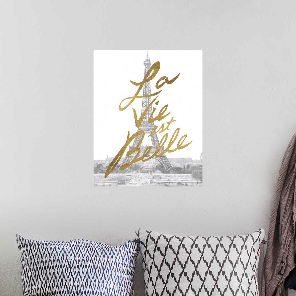 A bohemian room featuring Gold handlettering against a muted black and white photograph of the Eiffel Tower in Paris.