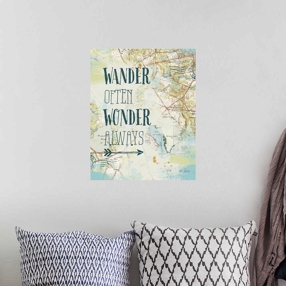 A bohemian room featuring "Wander Often Wonder Always" written on top of a map and postage stamp collage.