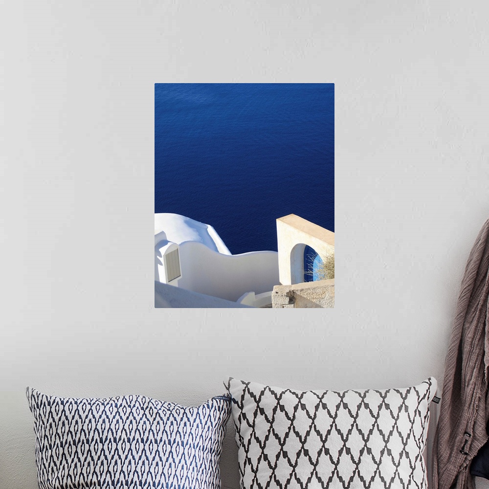 A bohemian room featuring Landscape photograph of the bright blue water in Santorini.