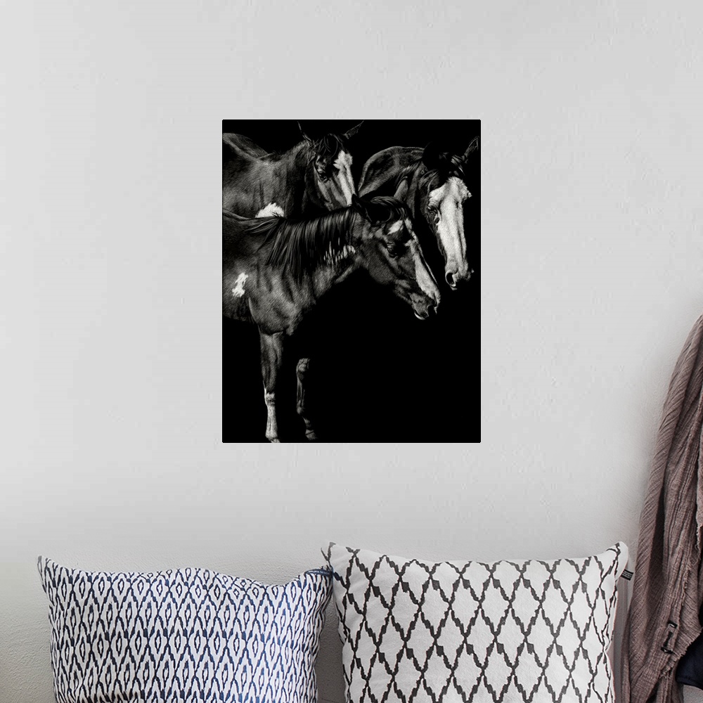 A bohemian room featuring Black and white illustration of three horses standing together.