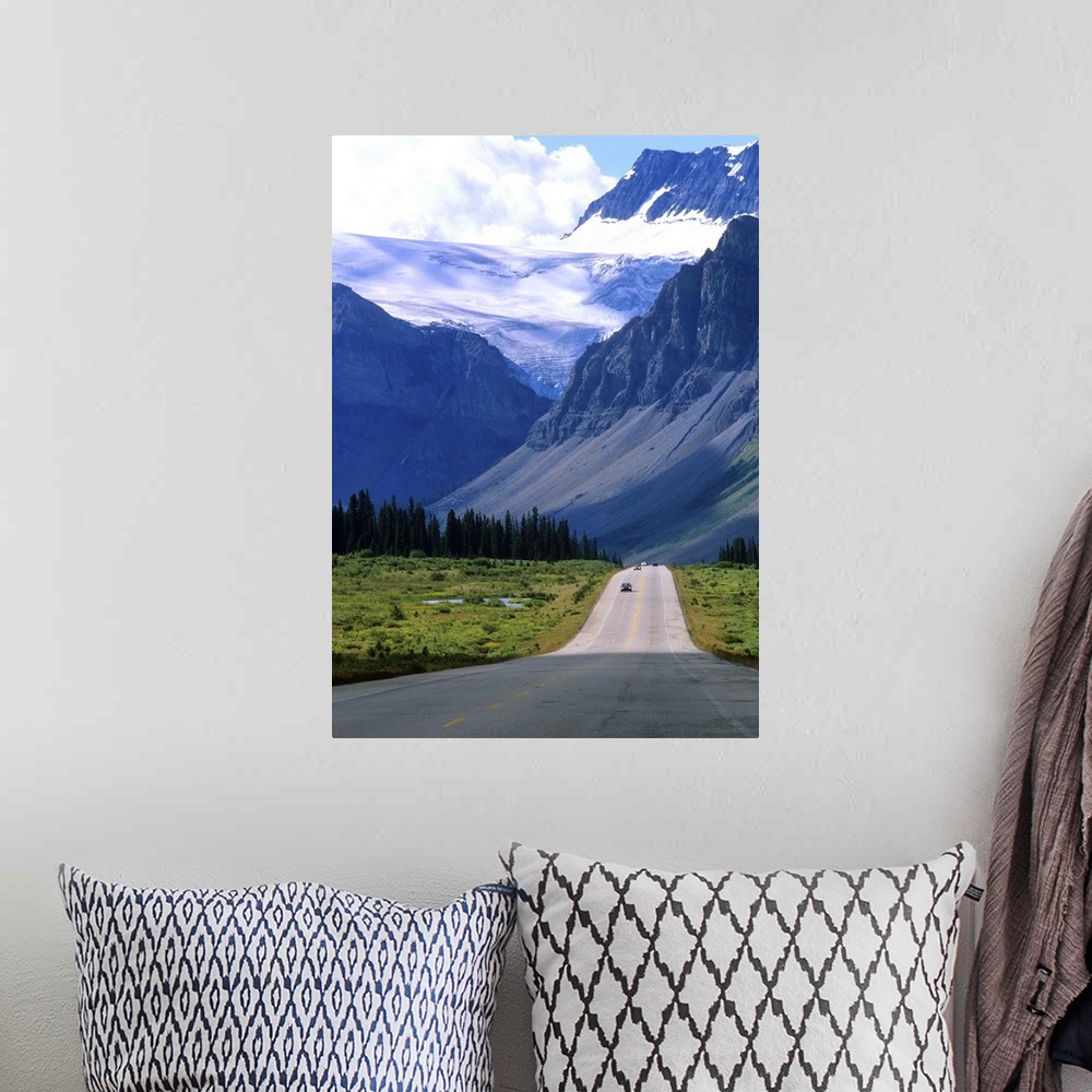 A bohemian room featuring A road into the mountains of Banff National Park, where fierce clouds and snowcapped peaks loom i...