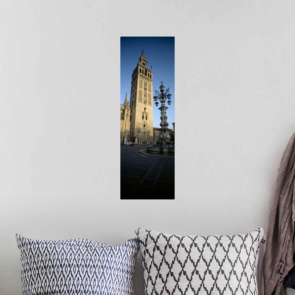 A bohemian room featuring Low angle view of a lamppost in front a church, La Giralda, Seville Cathedral, Seville, Seville P...
