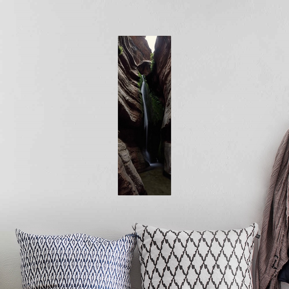 A bohemian room featuring Vertical panoramic photograph of cascading water falling between tall rock formations.