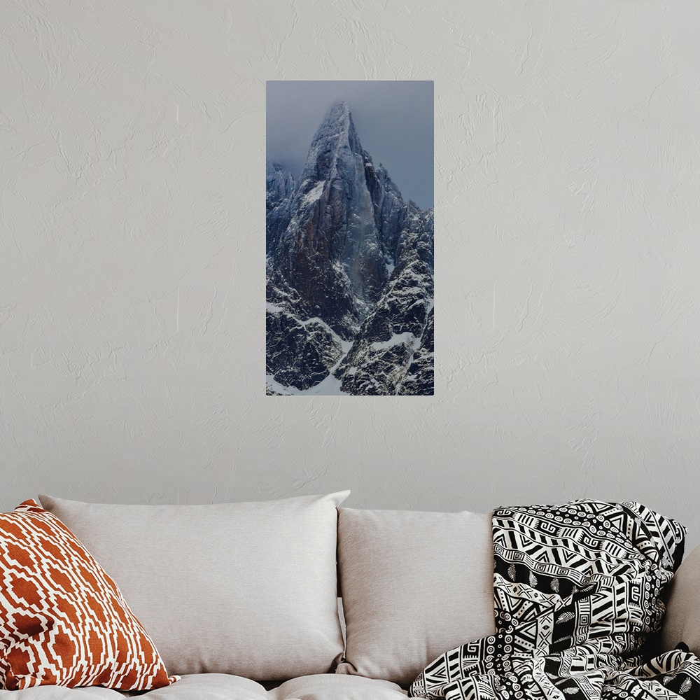 A bohemian room featuring Landscape photograph of the Aiguille du Dru in the Alps with a grey sky.
