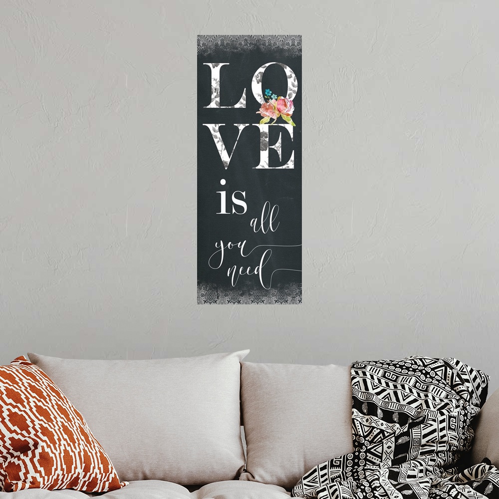 A bohemian room featuring Panel typography with a chalkboard feel that reads "Love is all you need" with a decorative patte...