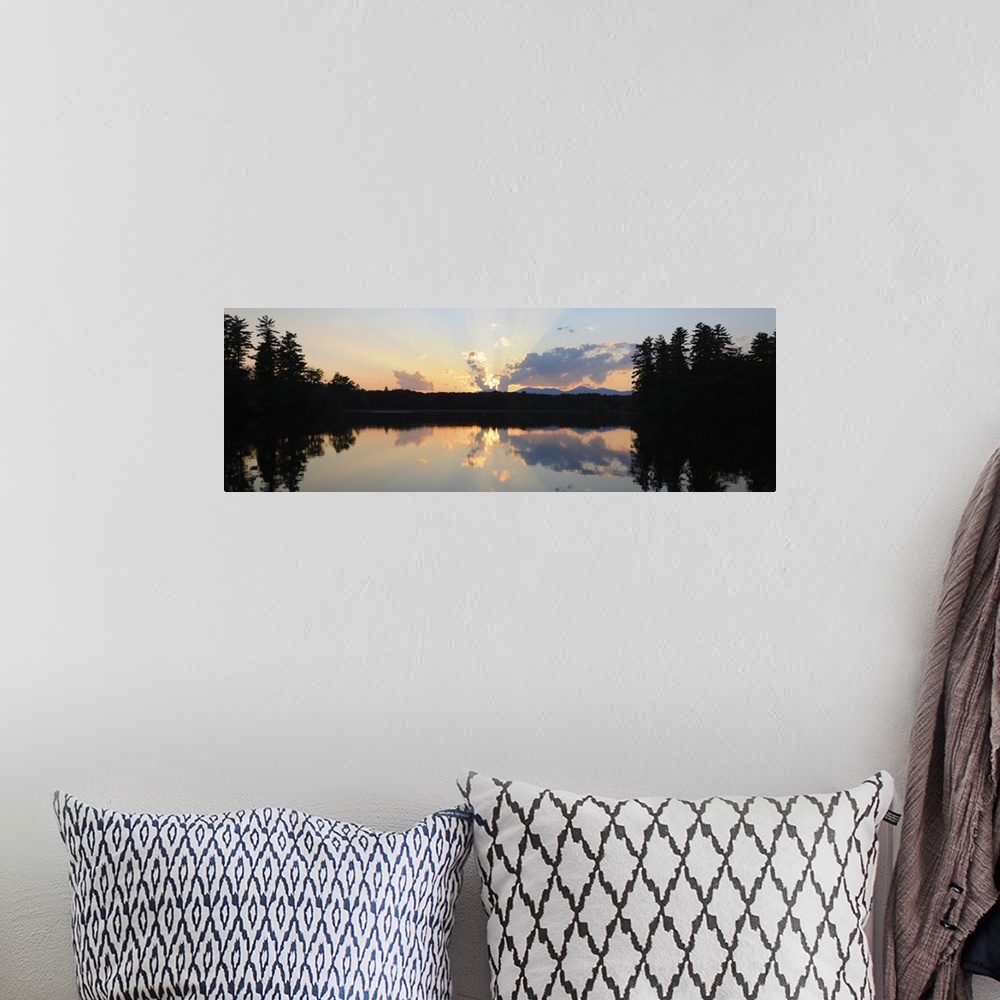 A bohemian room featuring A photograph of a beautiful sun rising over an idyllic landscape. Being reflected in a lake, whil...