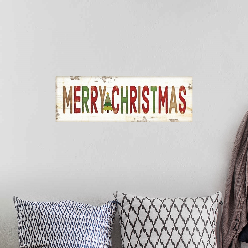 A bohemian room featuring Christmas themed typography artwork in festive seasonal colors against a distressed background.