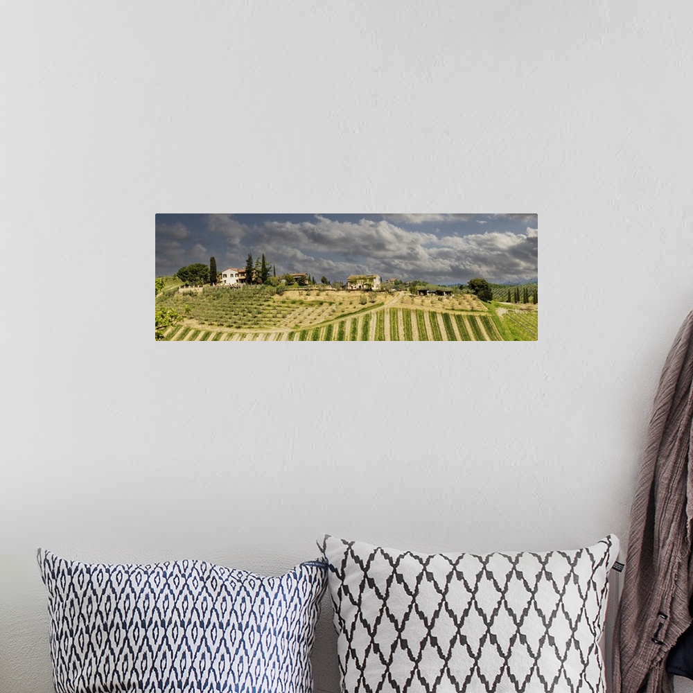 A bohemian room featuring Tuscan landscape under thunder clouds. Farmhouse with vineyard. Tuscany, Italy.