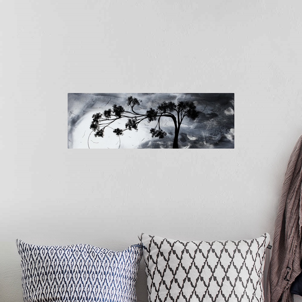 A bohemian room featuring Abstract artwork of a silhouetted tree that reaches far to the left against a gloomy sky with sev...
