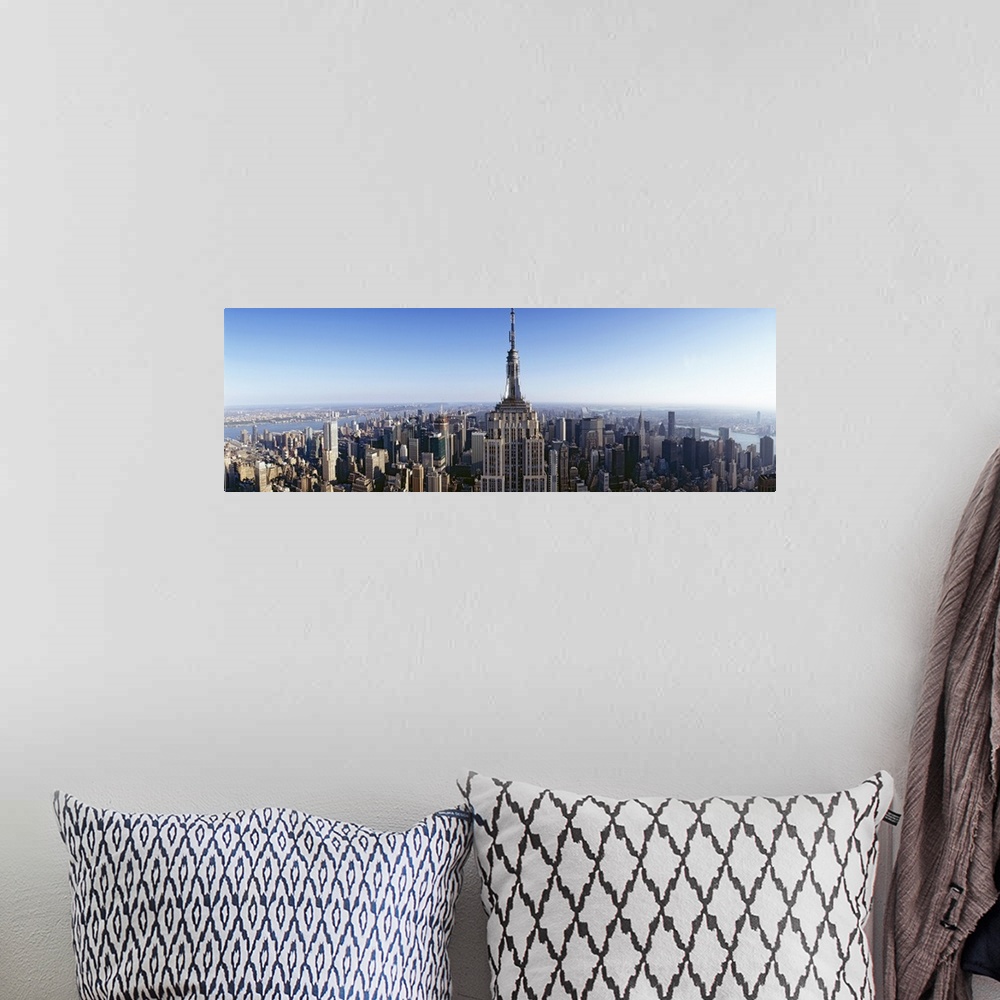 A bohemian room featuring Wide angle, aerial photograph of New York City beneath a blue sky, the Empire State Building in t...
