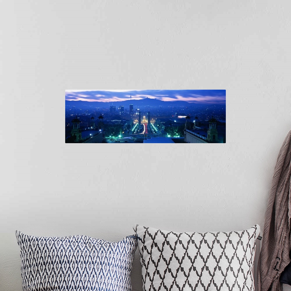 A bohemian room featuring Giant, high angle photograph of Barcelona, lit at night, mountains in the background beneath a mo...