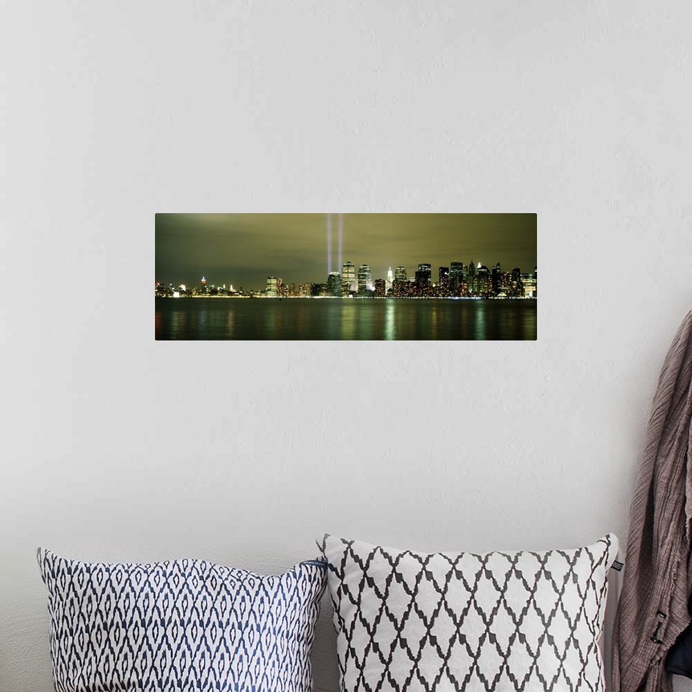 A bohemian room featuring Panoramic cityscape on canvas of NYC lit up with two beacons of light shooting upwards in place o...