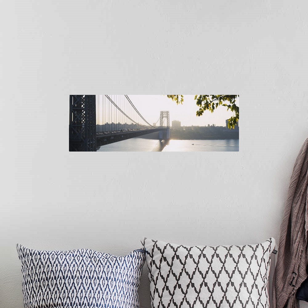 A bohemian room featuring The sun sets off in the distance over the George Washington bridge which is photographed in wide ...