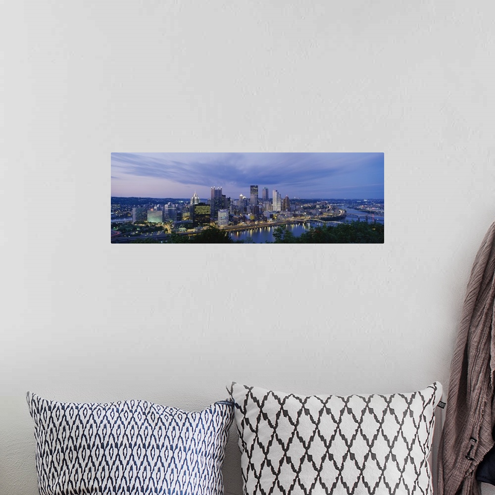 A bohemian room featuring A beautiful photograph of the Pittsburgh skyline lit up at dusk. The river and trees can be seen ...