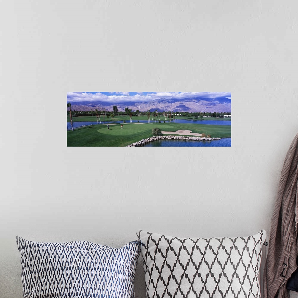 A bohemian room featuring This panoramic photograph shows the immaculate oasis with mountains and clouds in the distance.