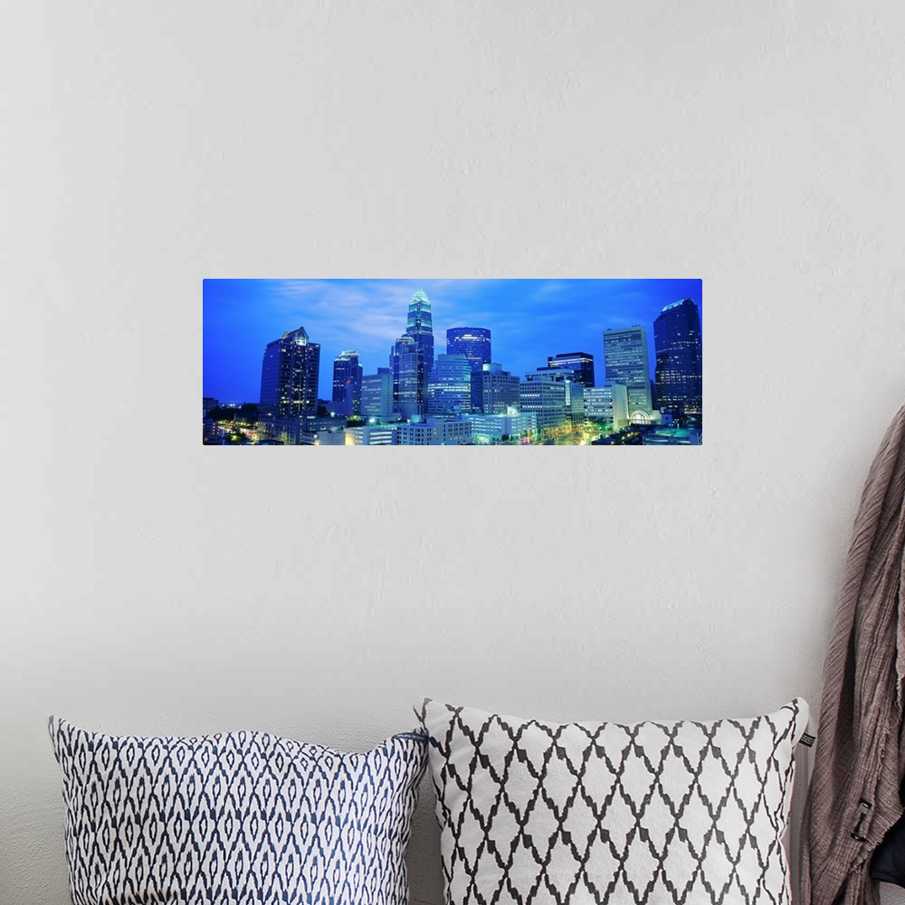 A bohemian room featuring Giant, panoramic photograph of the Charlotte skyline at night.