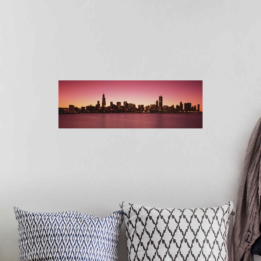 A bohemian room featuring Panoramic photograph of lit up skyline and waterfront at dusk.