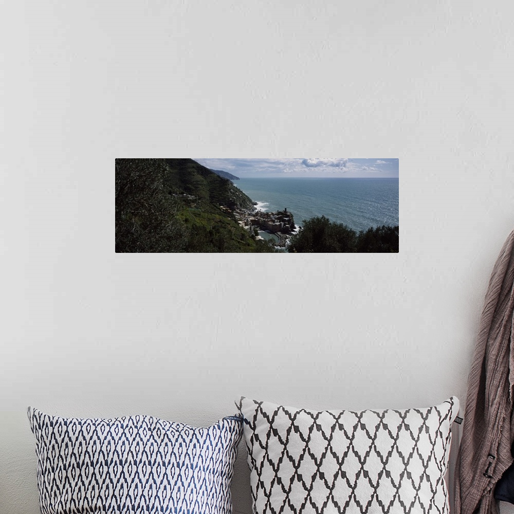 A bohemian room featuring Panoramic image of an Italian cliff leading to a city by the ocean on canvas.