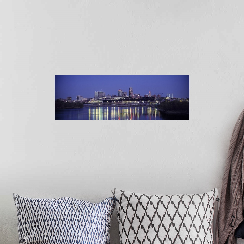 A bohemian room featuring Panoramic photograph of city skyline at dusk with the buildings lit up in the night sky.  The bri...