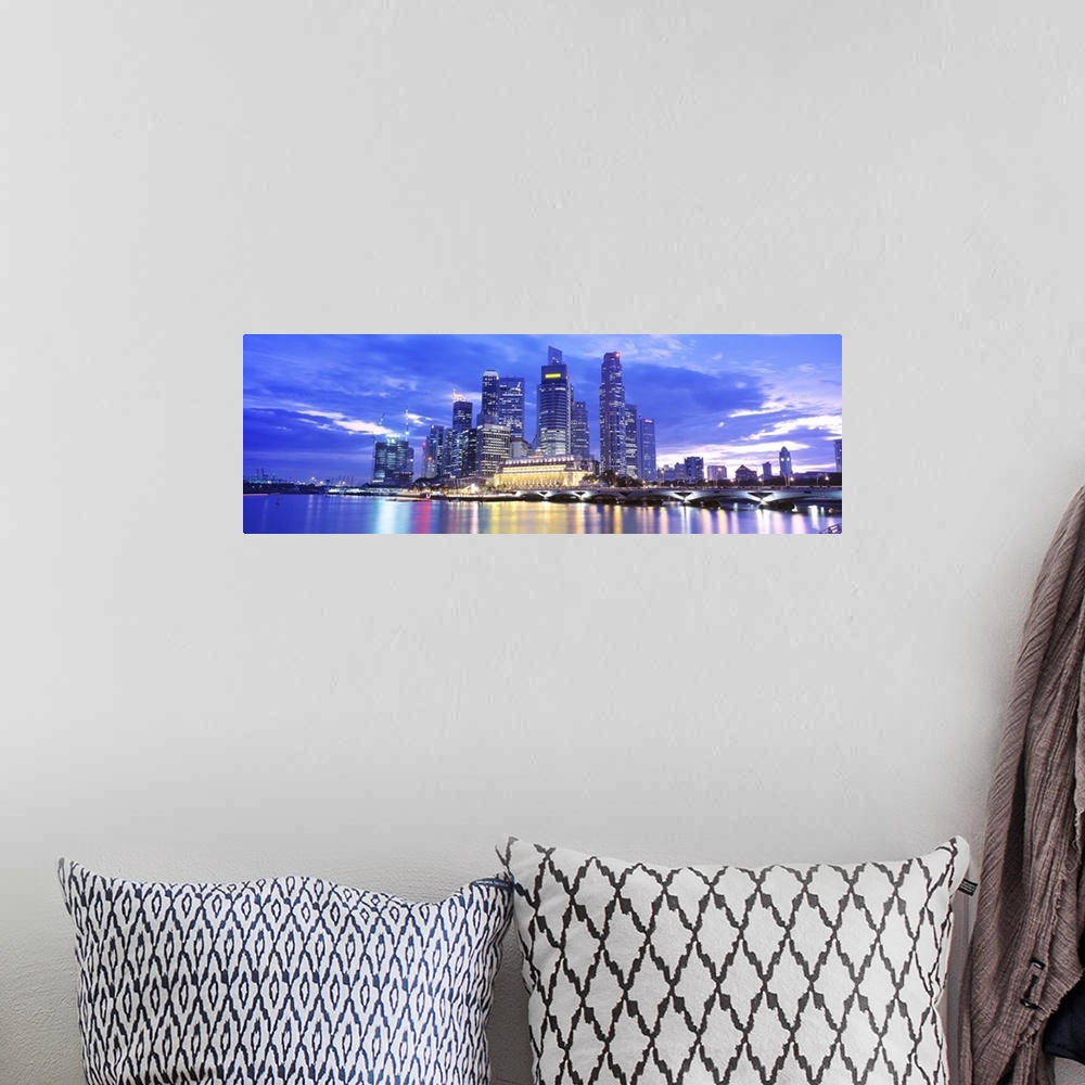 A bohemian room featuring A large panoramic photograph taken of a skyline in Singapore during the evening with all of the b...