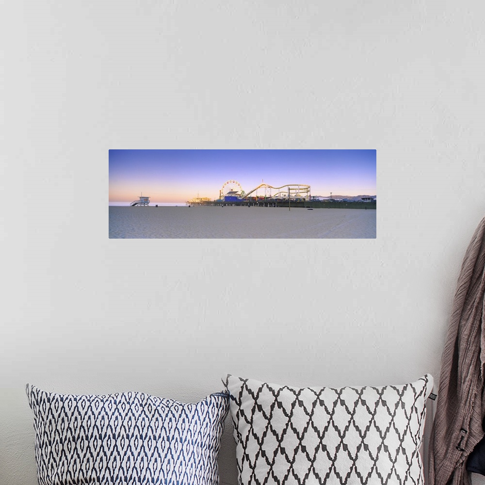 A bohemian room featuring This is a panoramic photograph of a board walk carnival taken from a sandy beach at twilight.