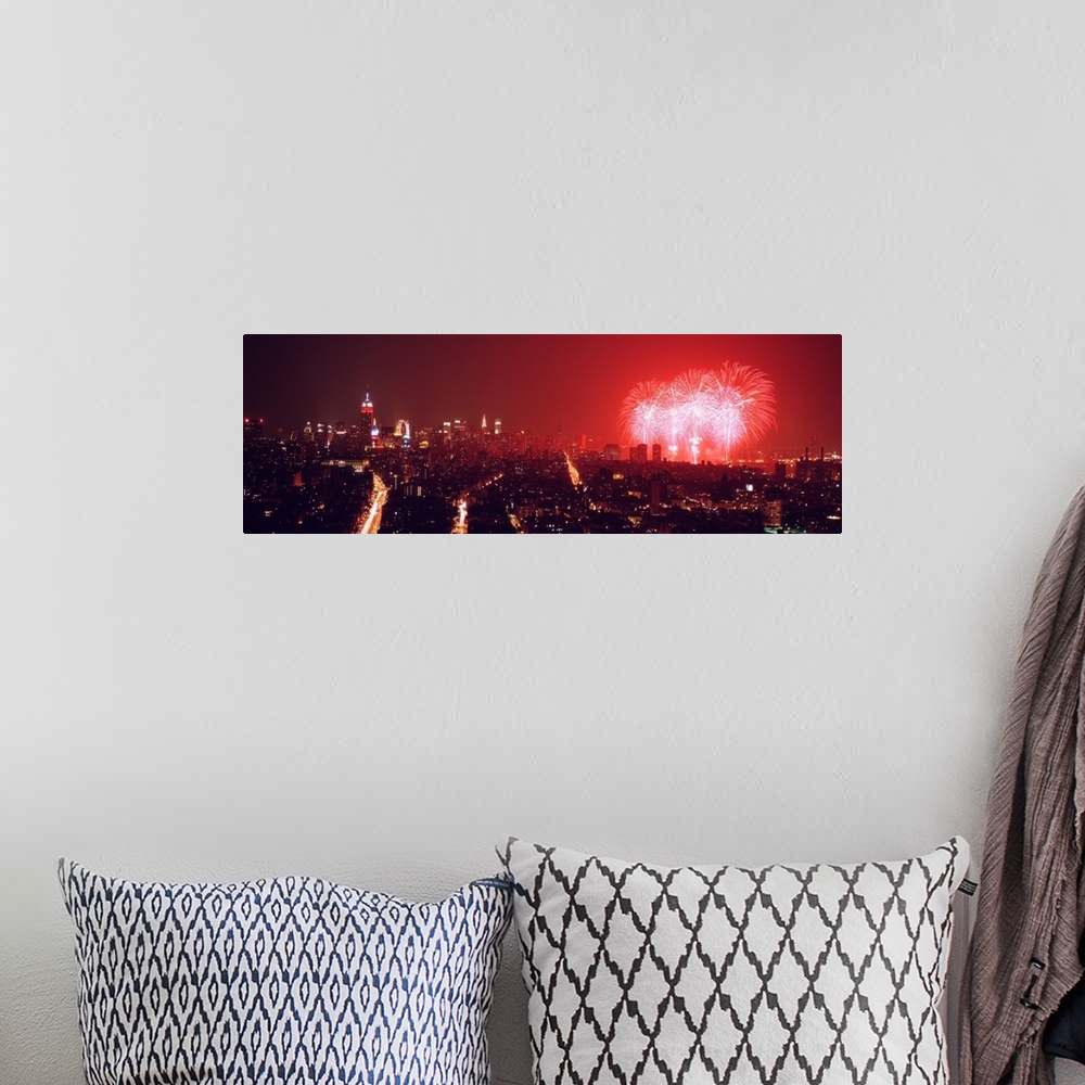 A bohemian room featuring This glowing panoramic wall art captures the burst of three rockets over the water as well as sev...